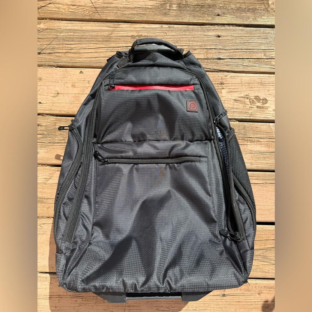 Black carry on size backpack with wheels and retractable handle